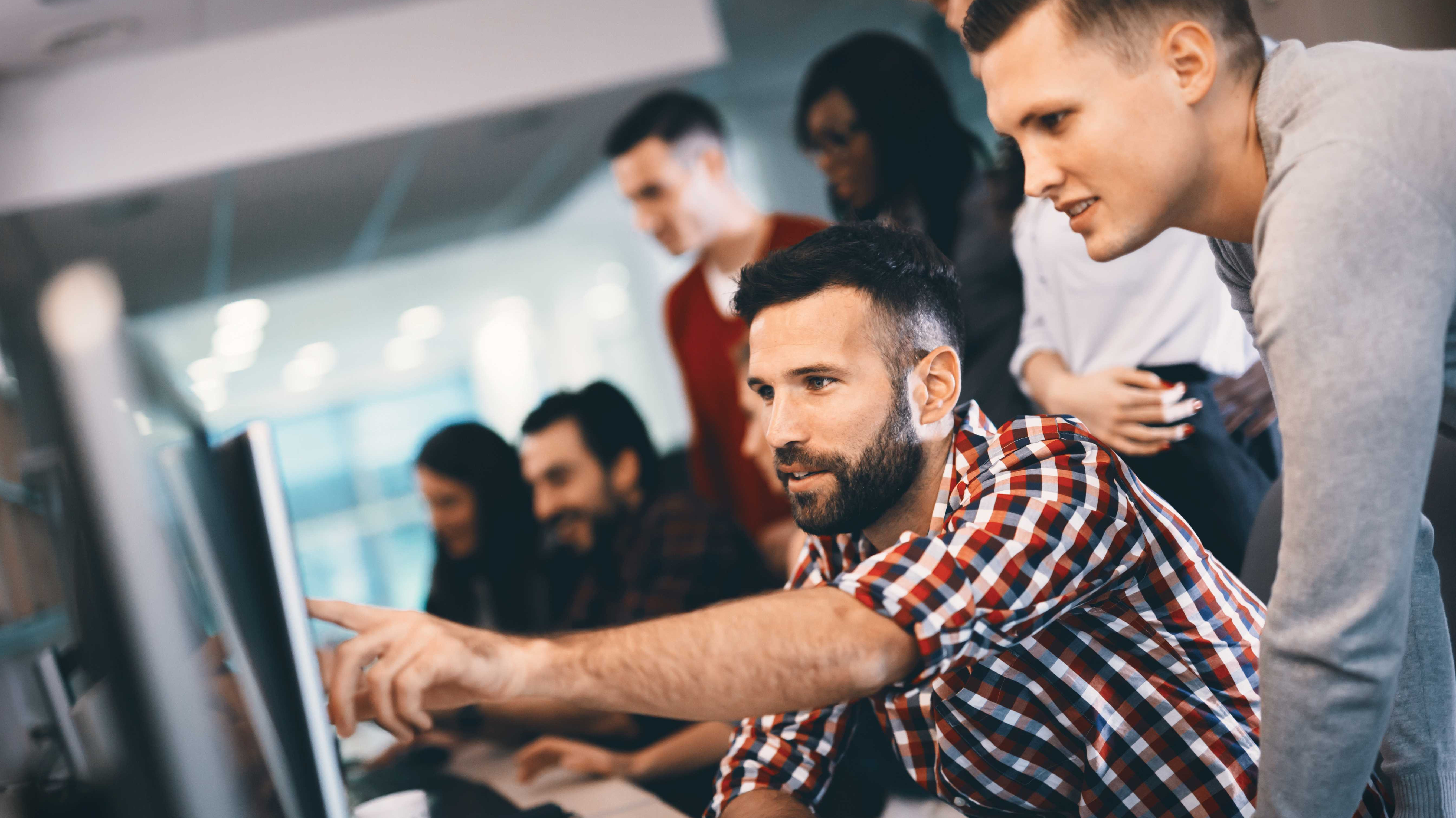 Zwei Kollegen arbeiten an Softwaresystemen am PC