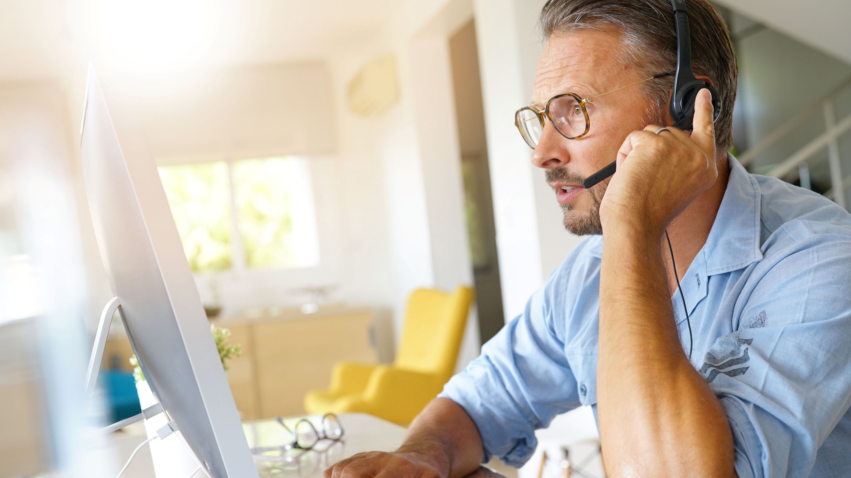 Ein Mann mit Headset arbeitet im Homeoffice