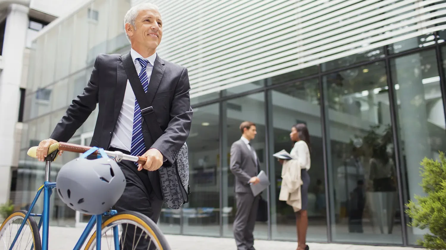 Ein Mann steht mit dem Fahrrad vor dem Büro. 