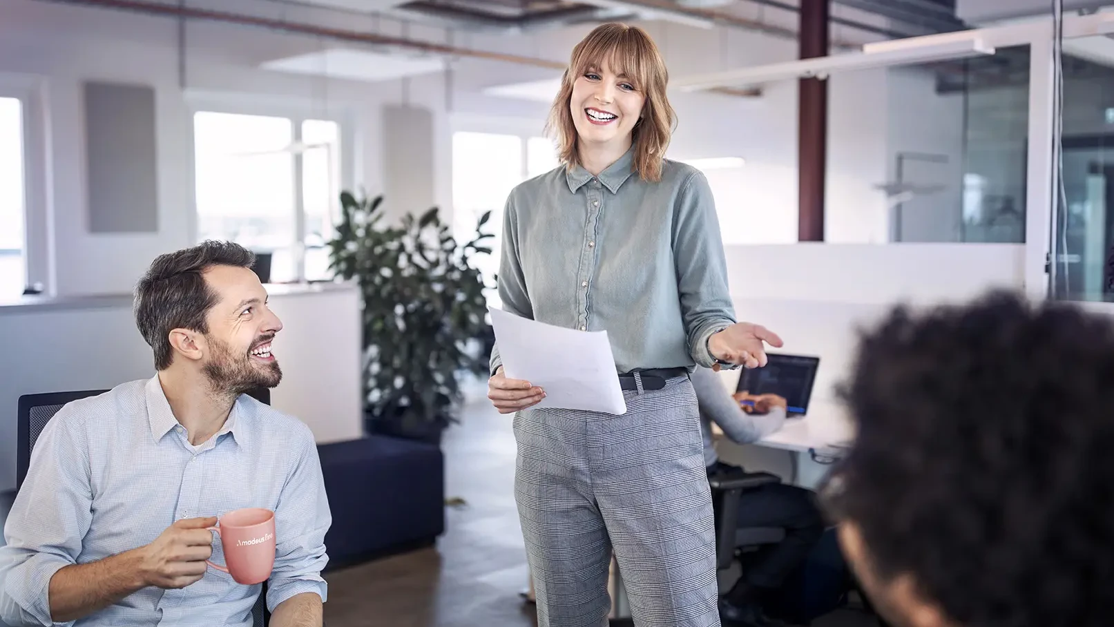 Eine Frau hält im Office eine Präsentation für ihre Kollegen