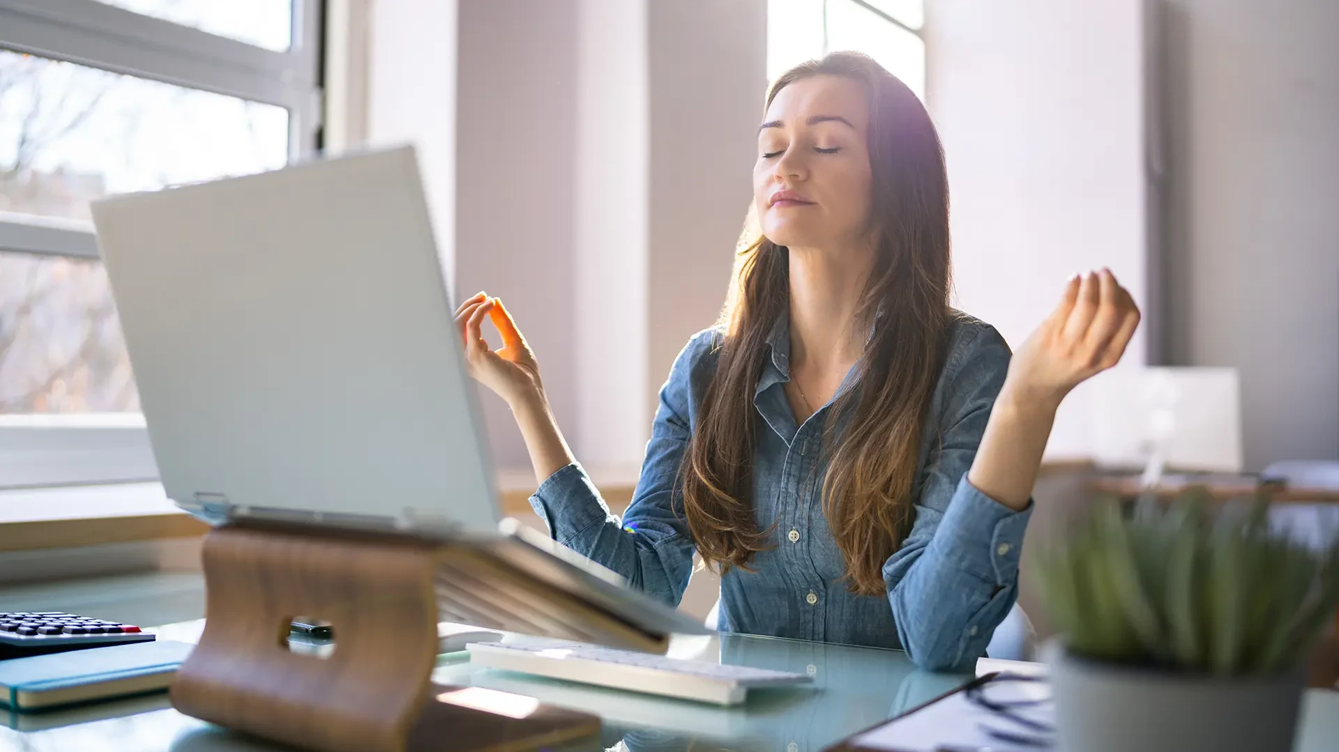 Eine Frau meditiert am Arbeitsplatz