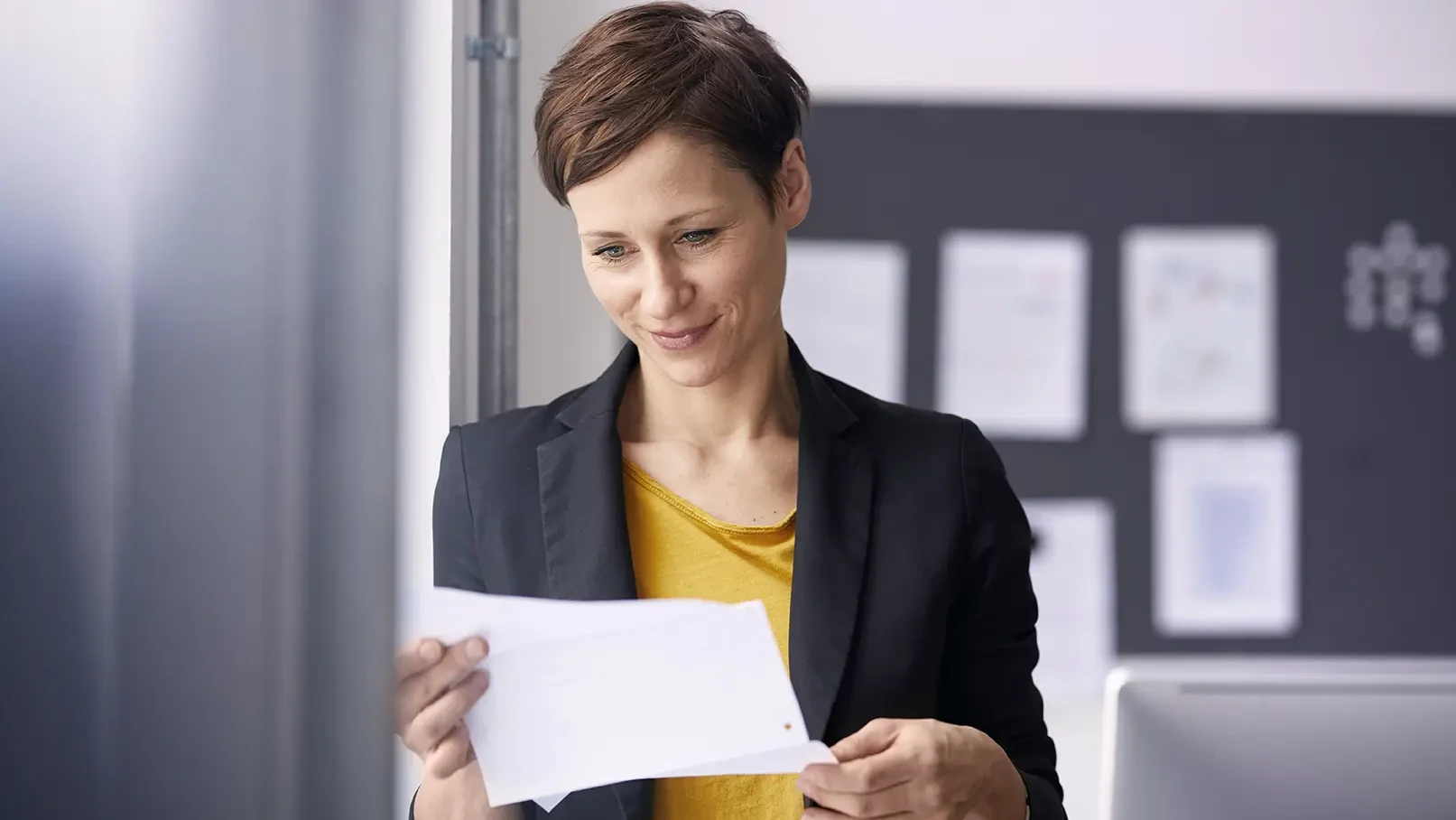 Eine Business Frau schaut sich den Gehaltsvergleich auf einem Zettel an