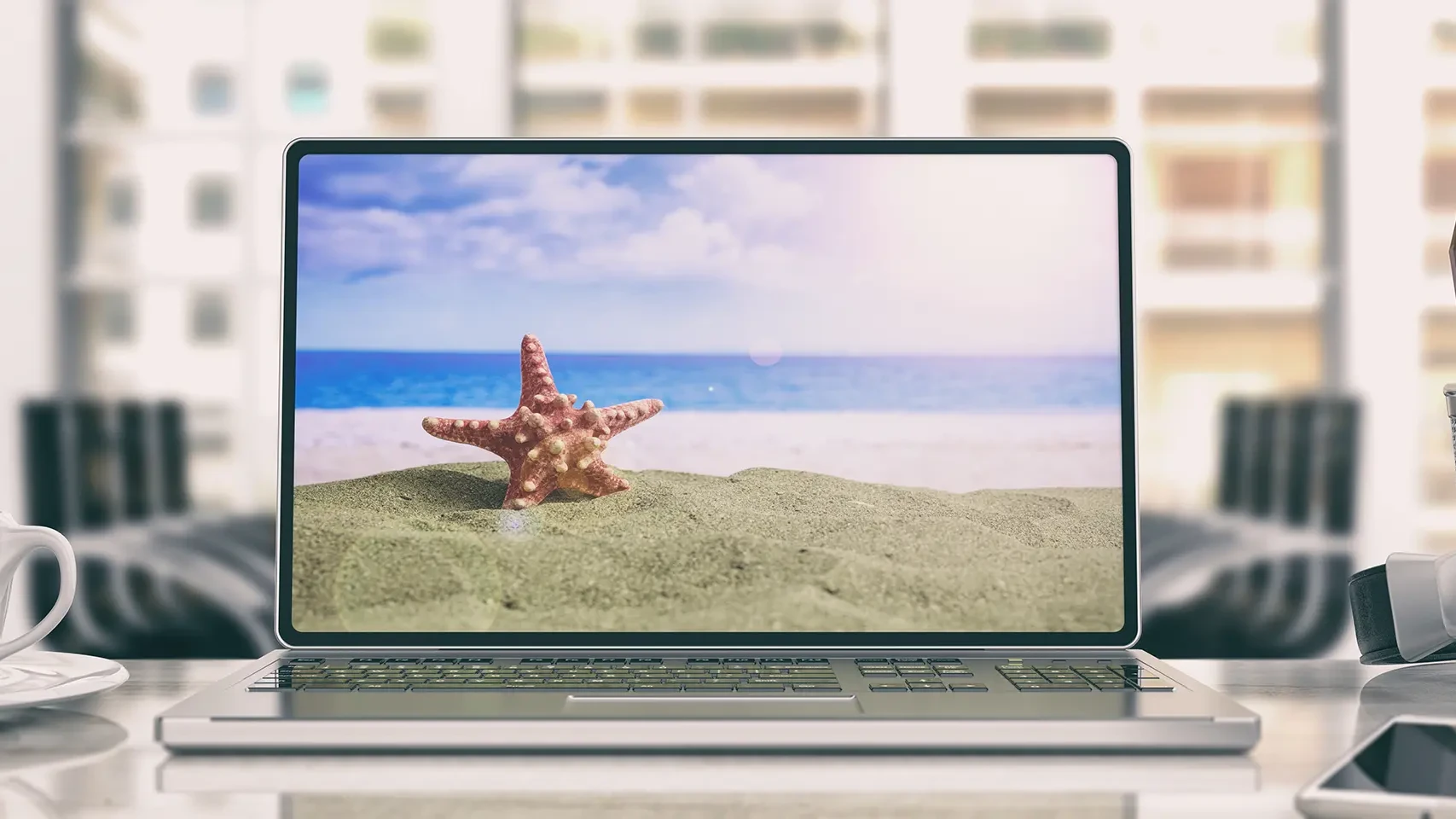 Auf einem Laptop Bildschirm sieht man einen Sandstrand mit einem Sternfisch