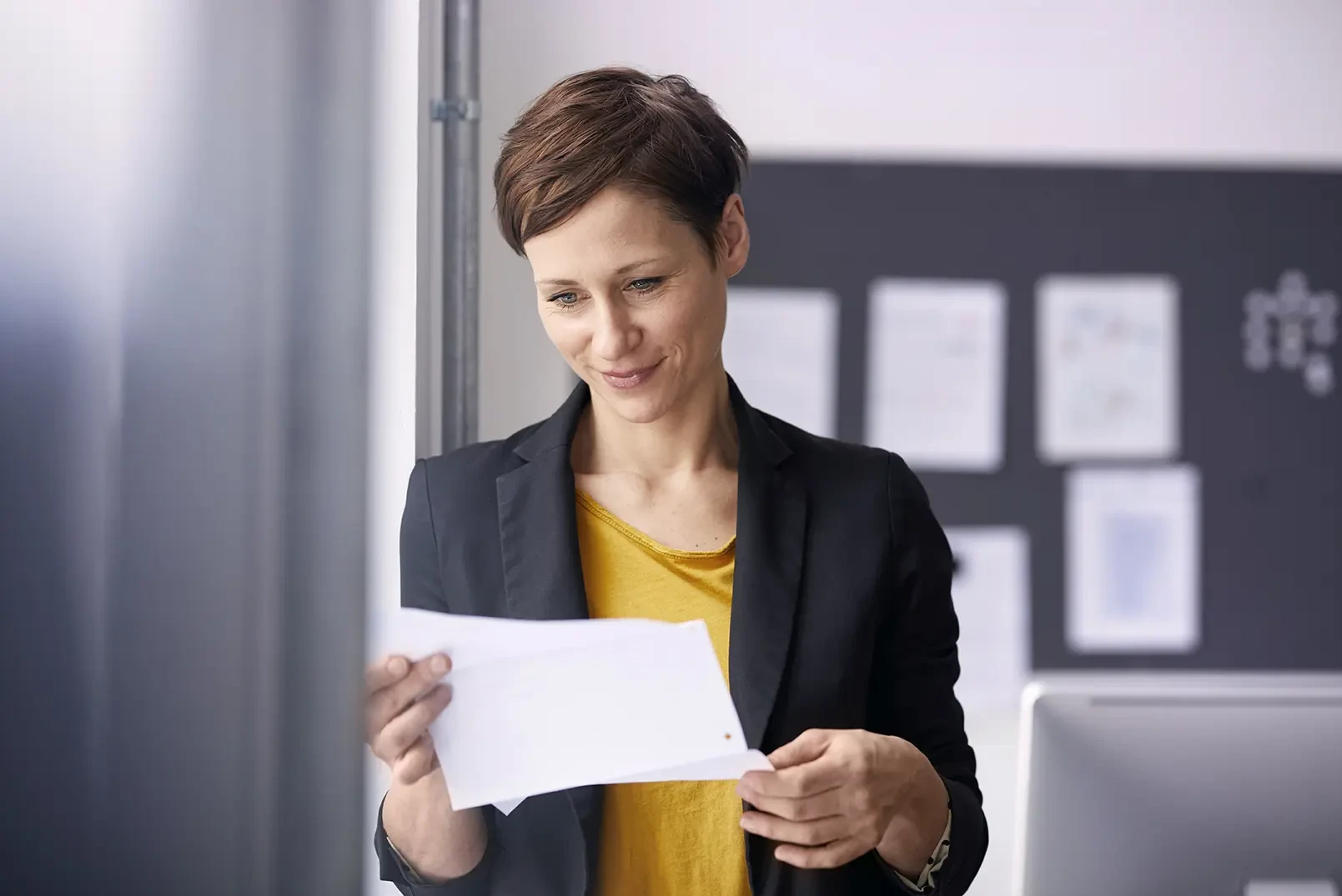 Eine Business Frau schaut auf einen Zettel mit Gehaltsvergleich.