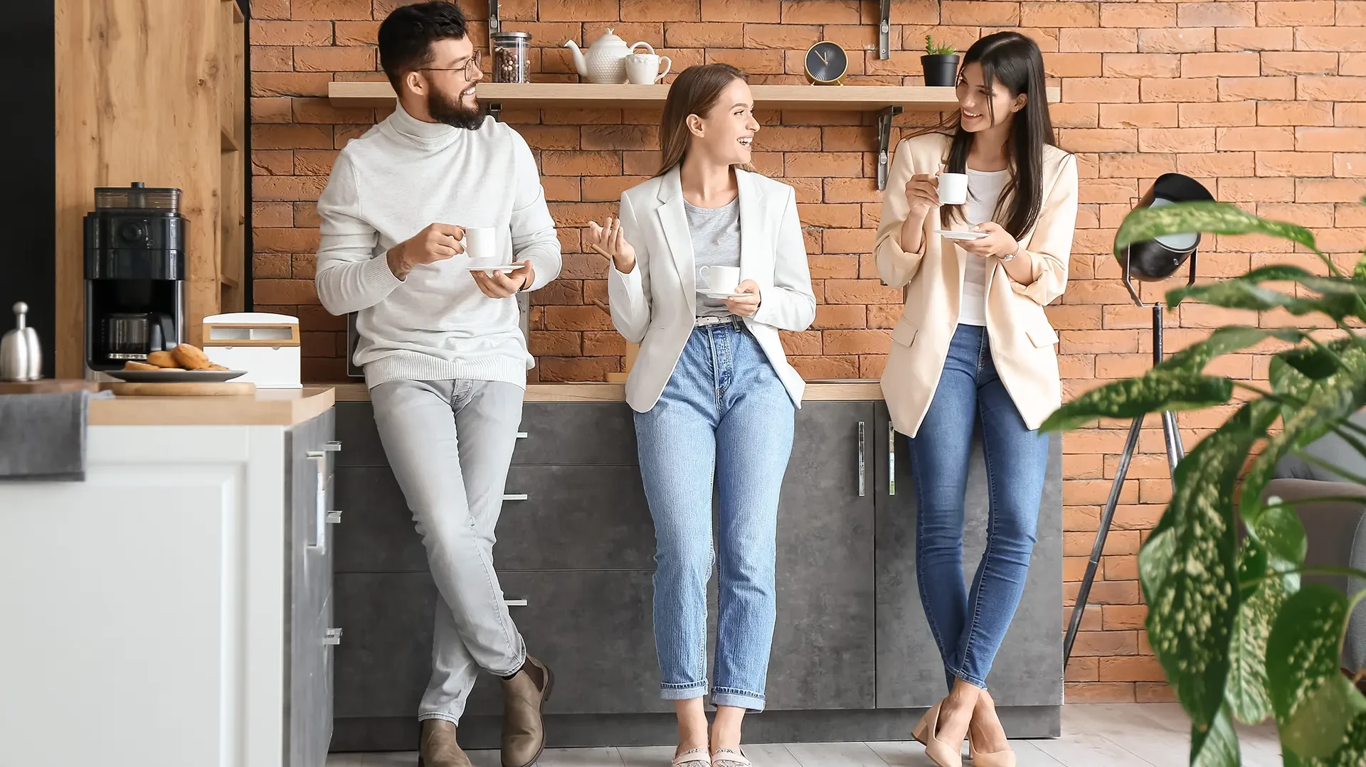 Eine Gruppe von Arbeitskollegen beim Kaffee trinken in der Küche