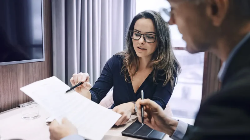 Zwei-Business-Kollegen-besprechen-Dokument_Maskot